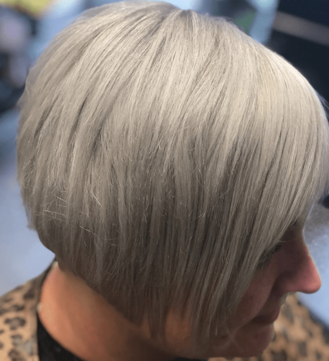 A woman with short gray hair is wearing a leopard print jacket.