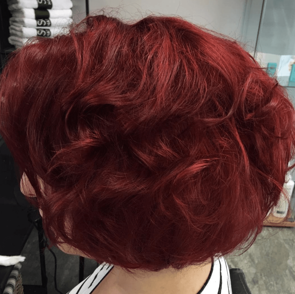 A woman with red hair is wearing a white and black shirt.