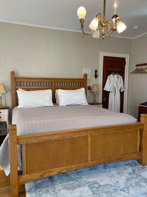 A bedroom with a king size bed and a chandelier