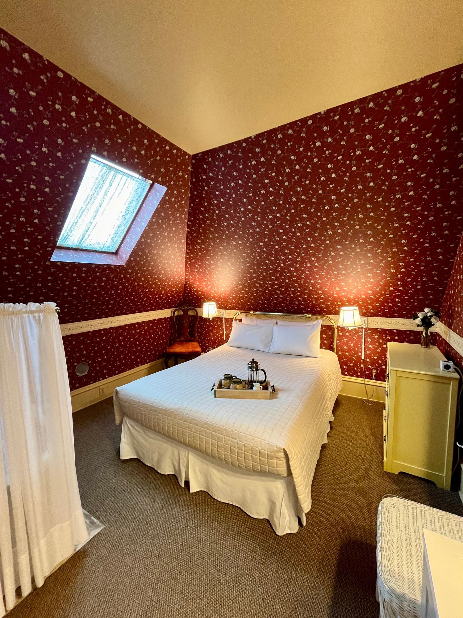 A bedroom with a bed and a skylight on the ceiling