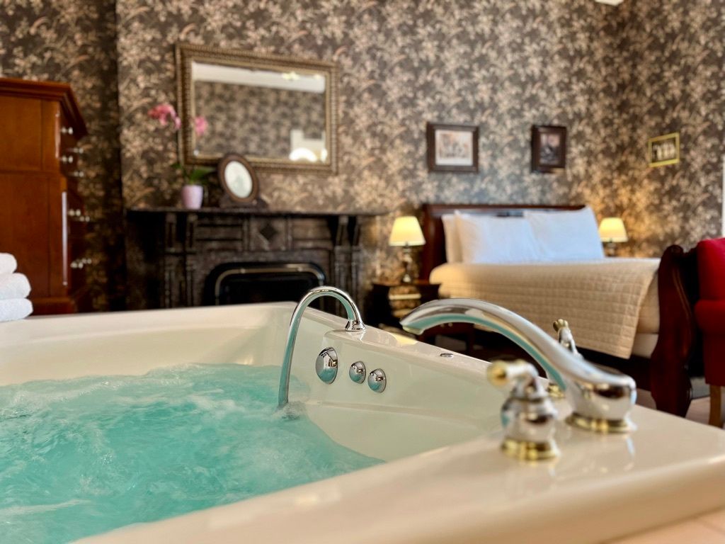 A jacuzzi tub in a hotel room next to a bed.