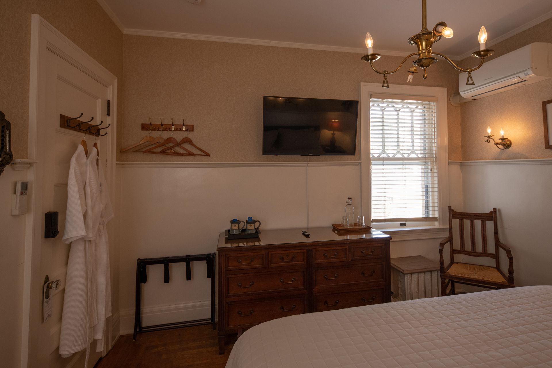 A bedroom with a bed , dresser , chair and television.