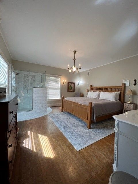 A bedroom with a large bed and a walk in shower