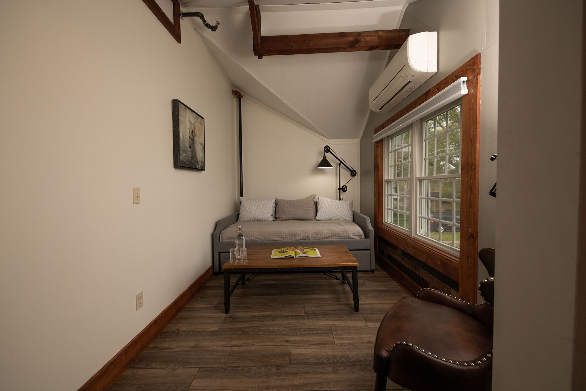 A living room with a couch , table , chair and window.