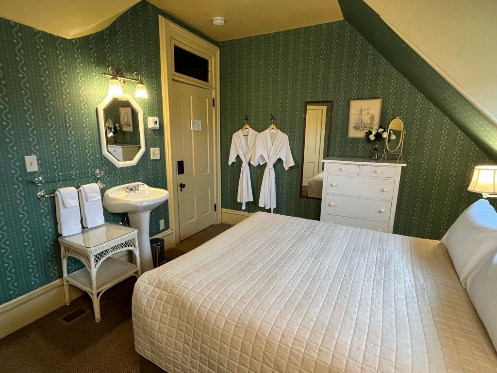 A bedroom with a bed , sink and mirror.