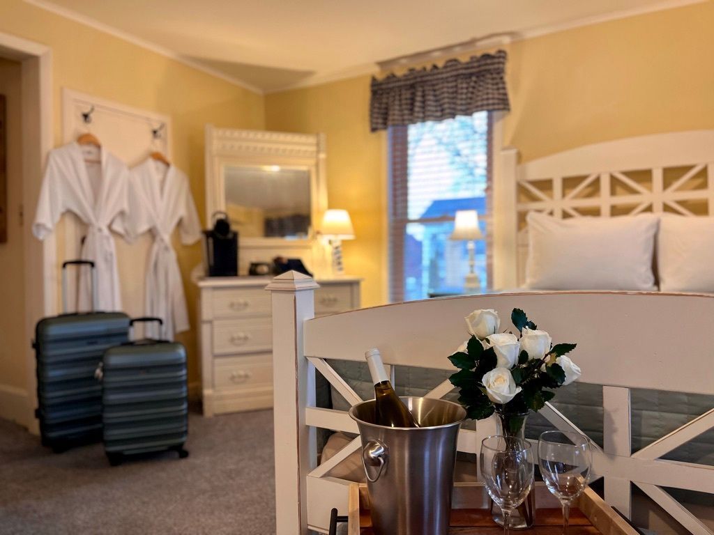 A hotel room with a bed and a bucket of champagne