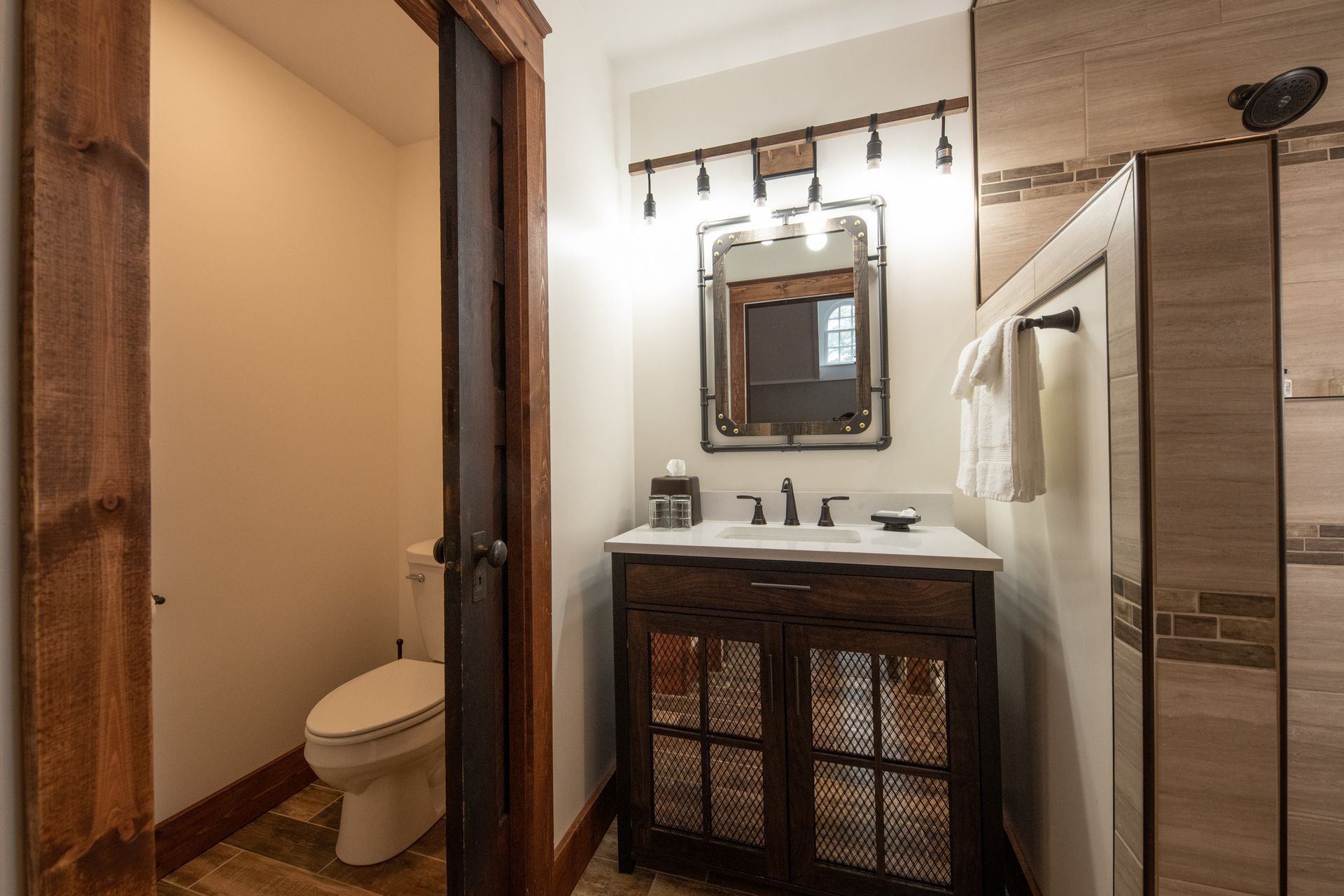 A bathroom with a sink , toilet and mirror.