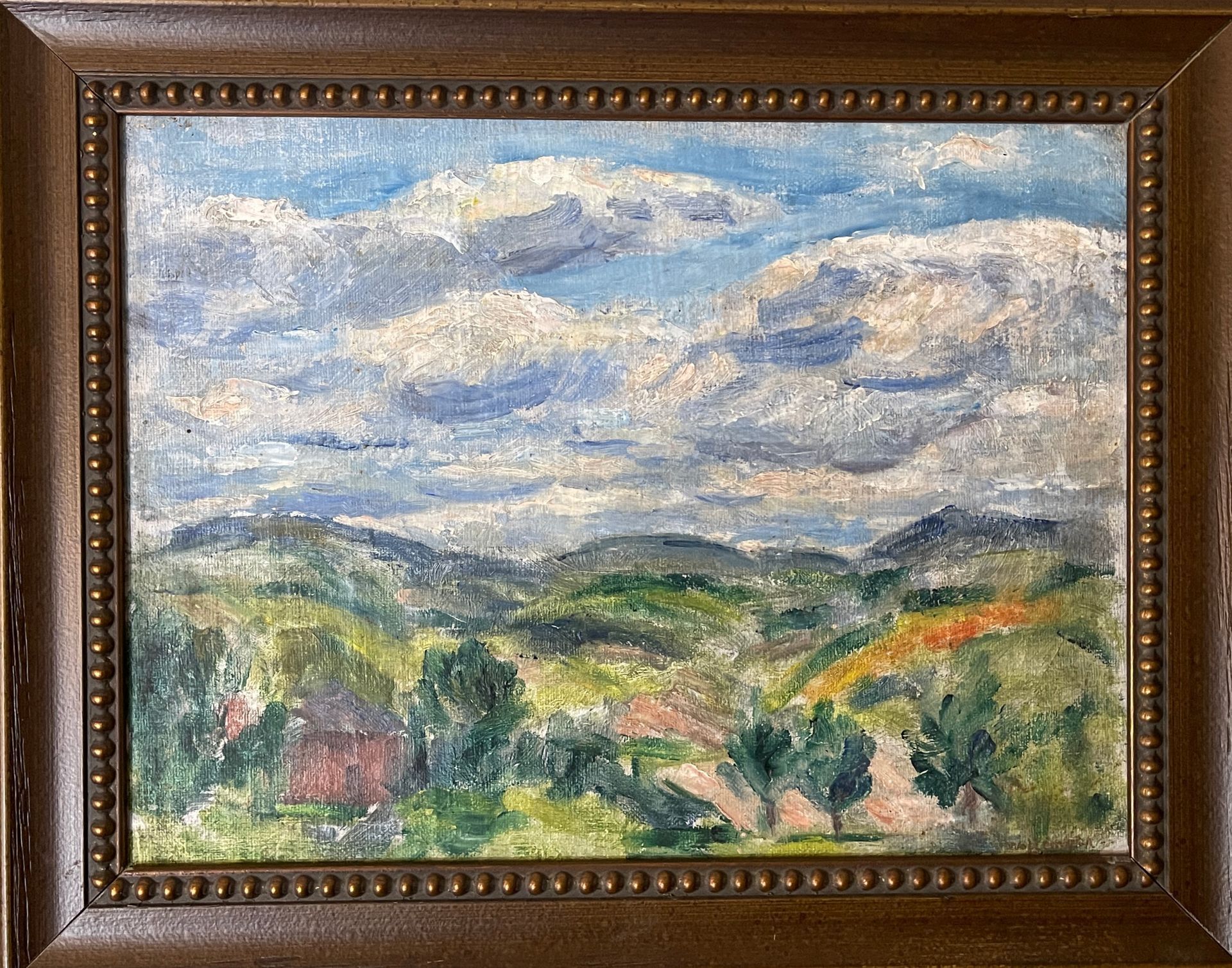 A framed painting of a landscape with trees and clouds