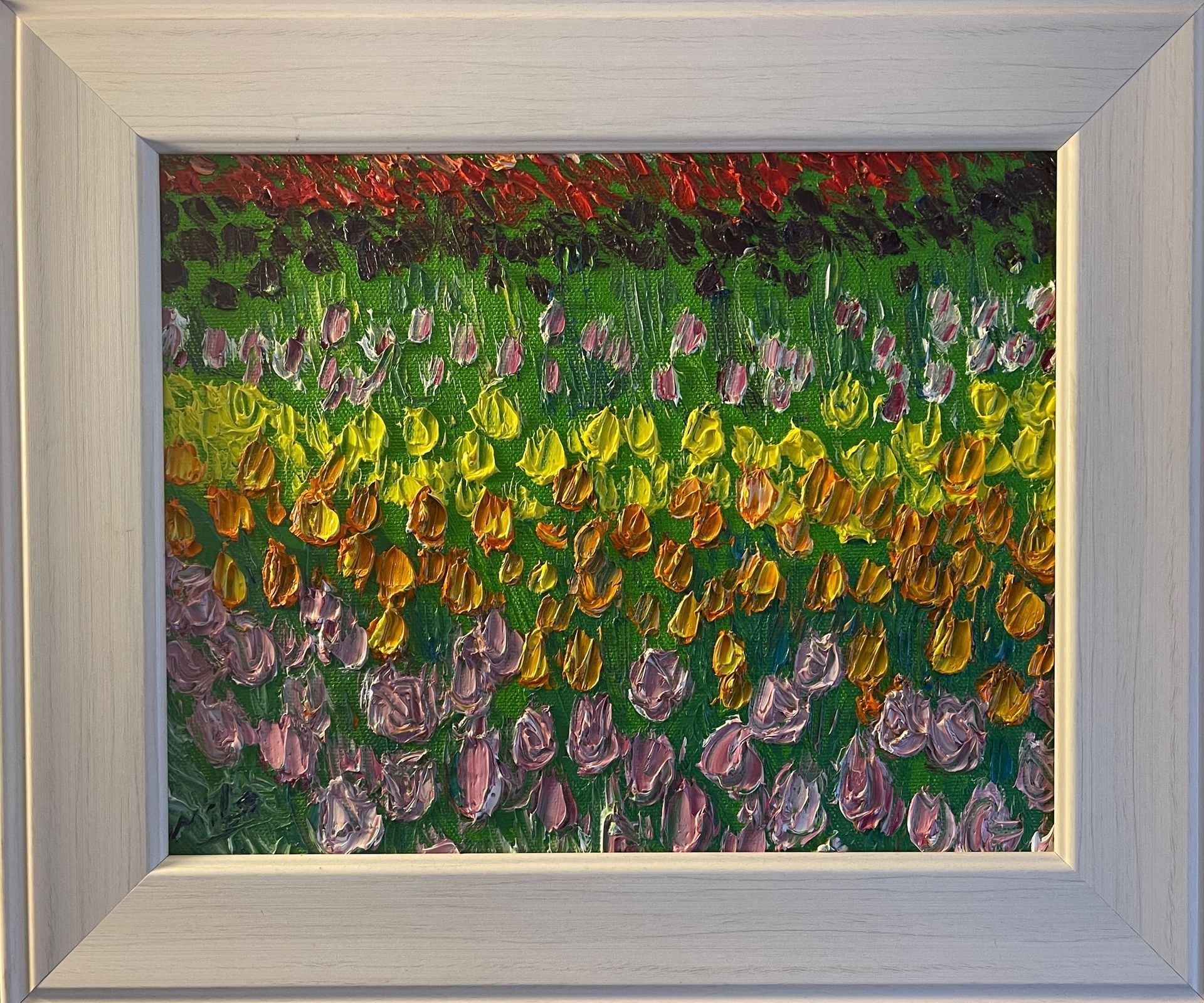 A painting of flowers in a white frame