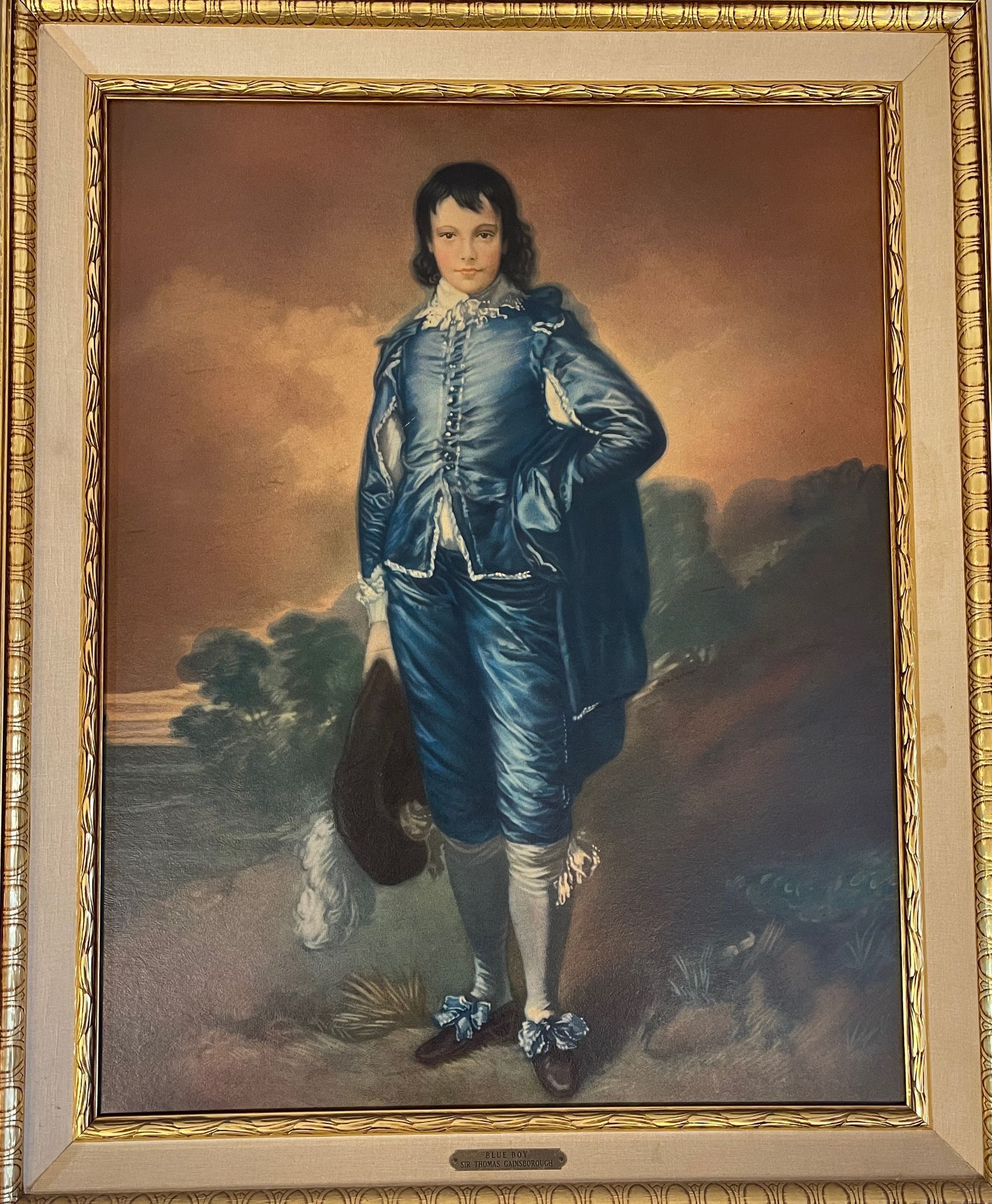 A framed painting of a young man in a blue suit