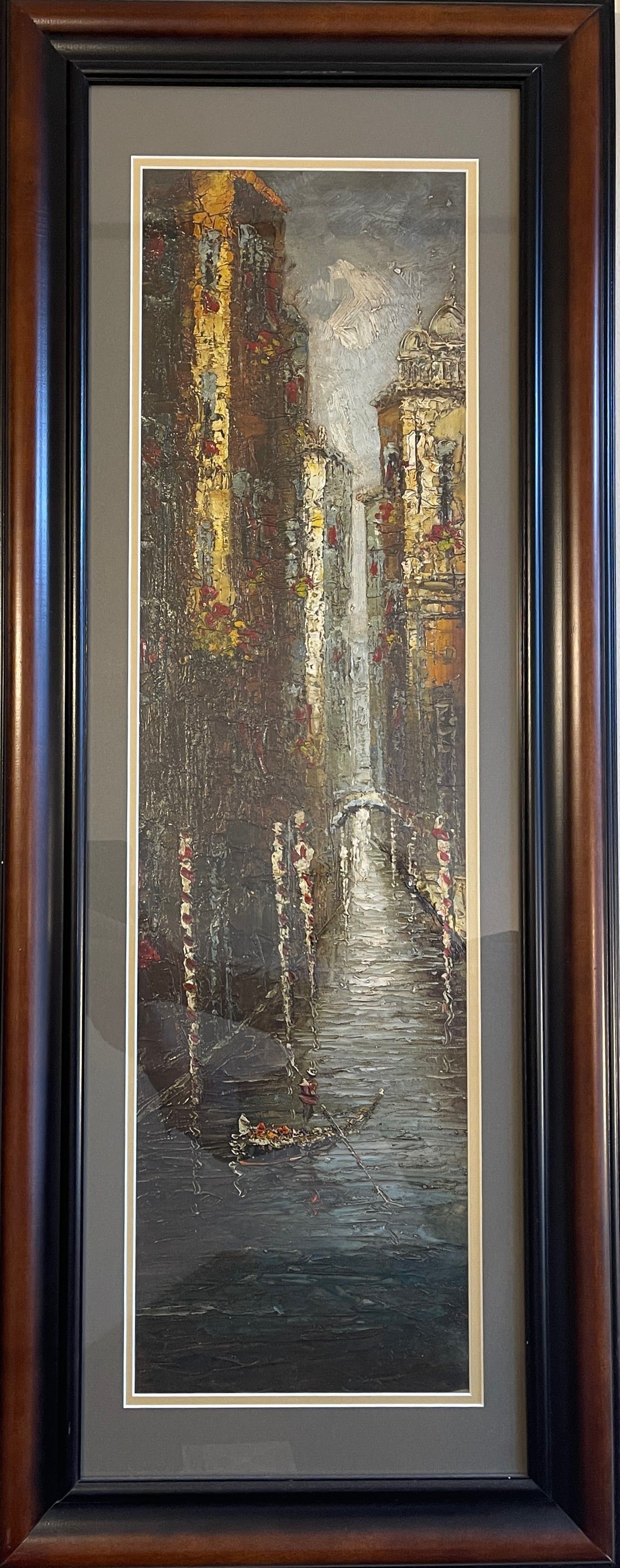 A framed painting of a waterfall is hanging on a wall.