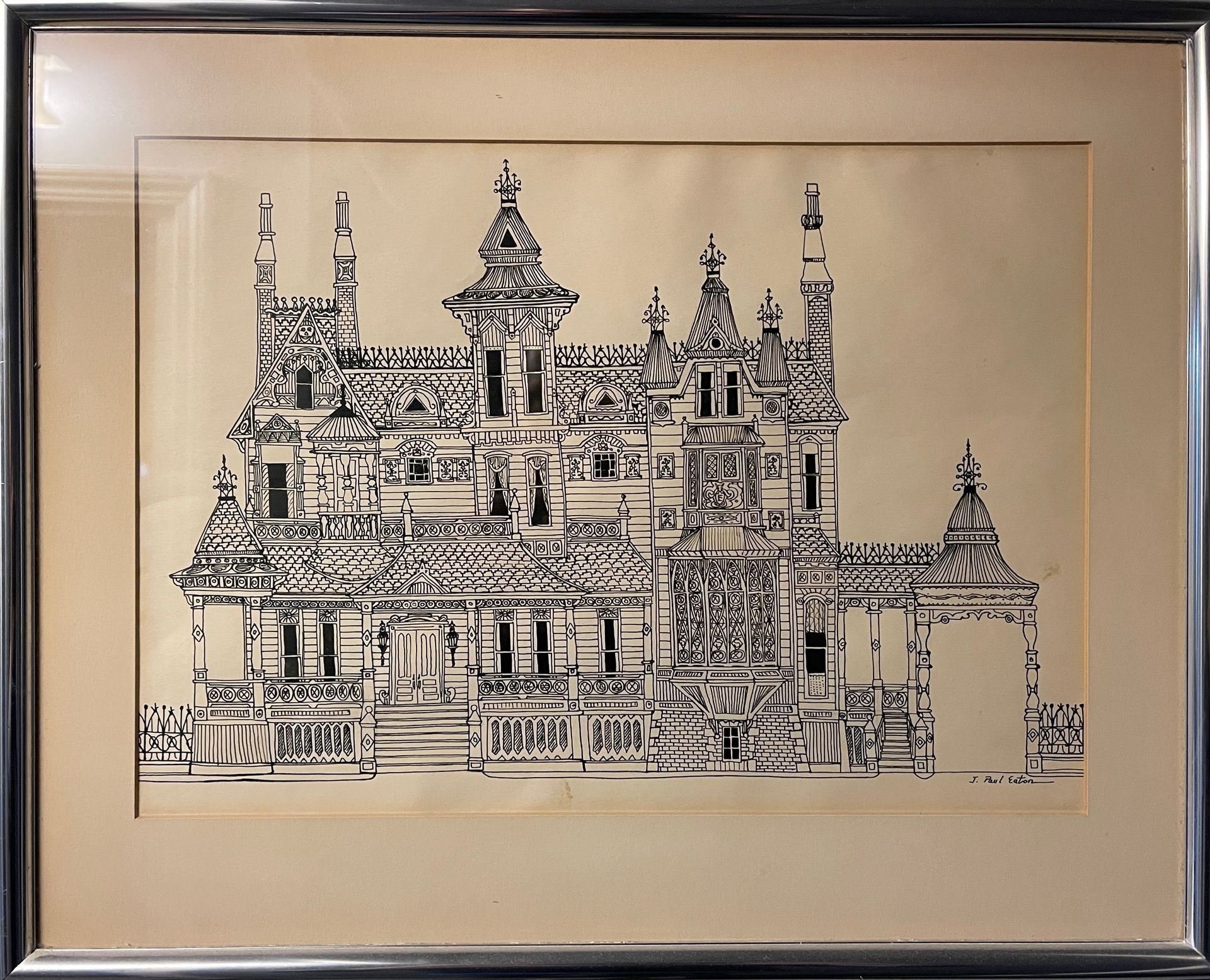 A black and white drawing of a castle in a silver frame