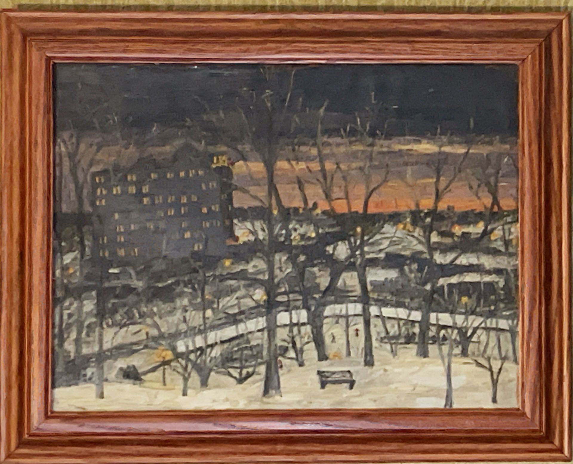A framed painting of a park with trees and buildings in the background