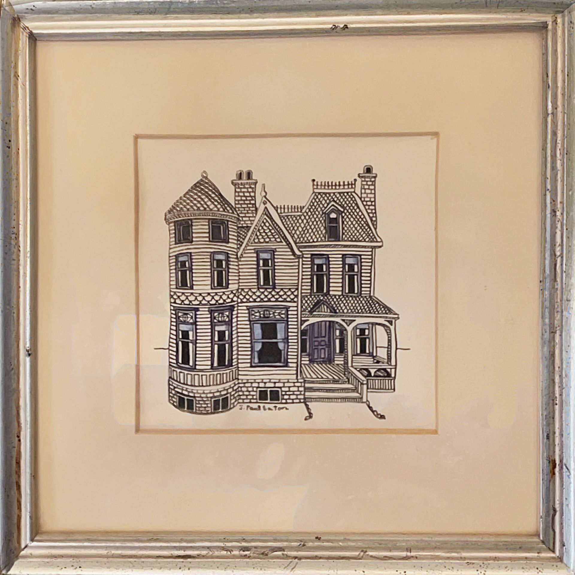 A picture of a house in a silver frame