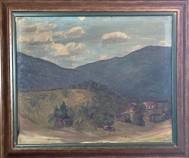 A painting of a landscape with mountains and houses in a wooden frame.