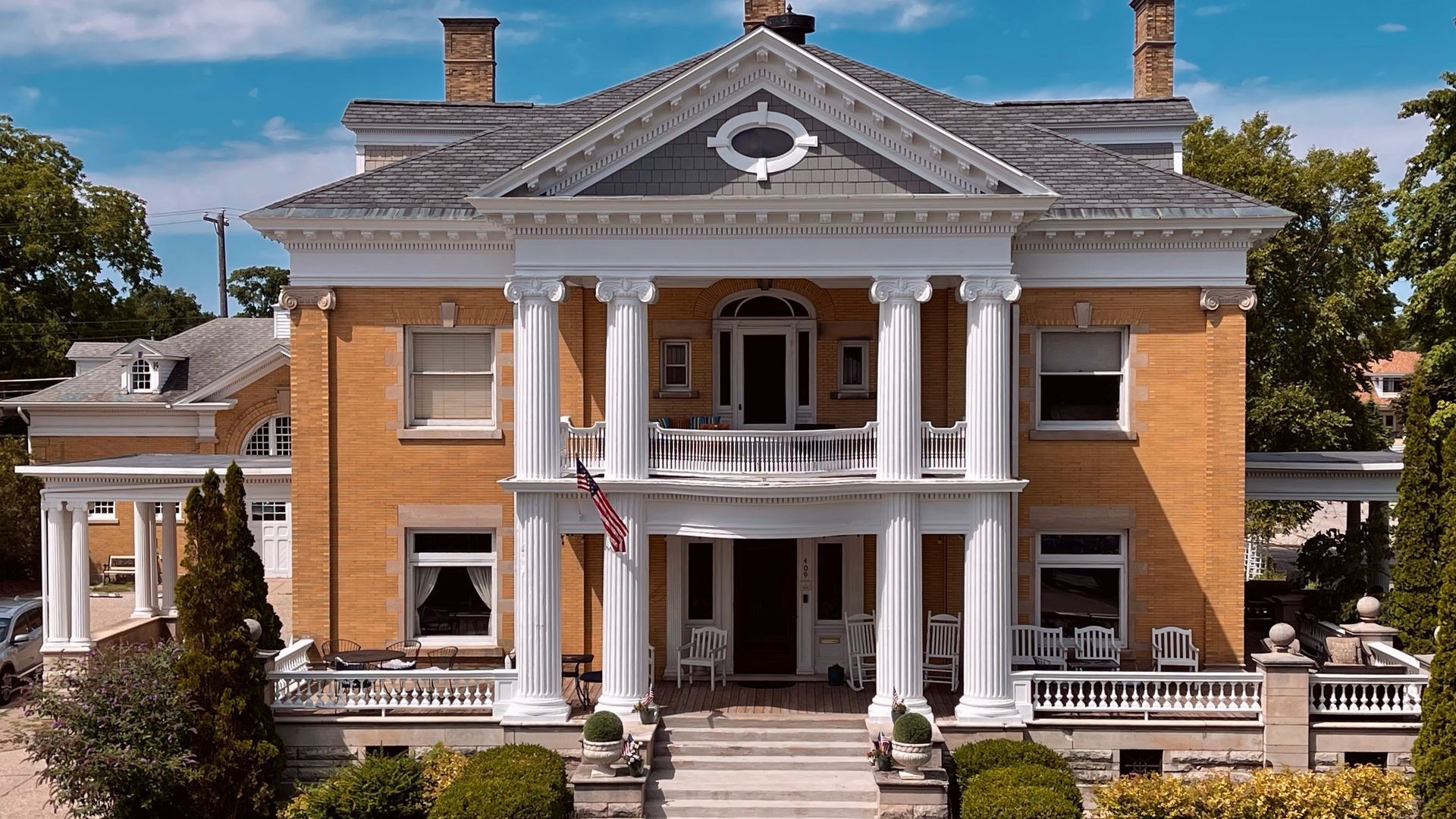 A large brick house with white columns and a porch