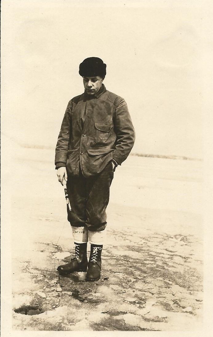 A black and white photo of a man standing in the snow