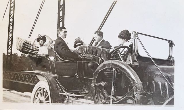 A group of people are sitting in an old car.