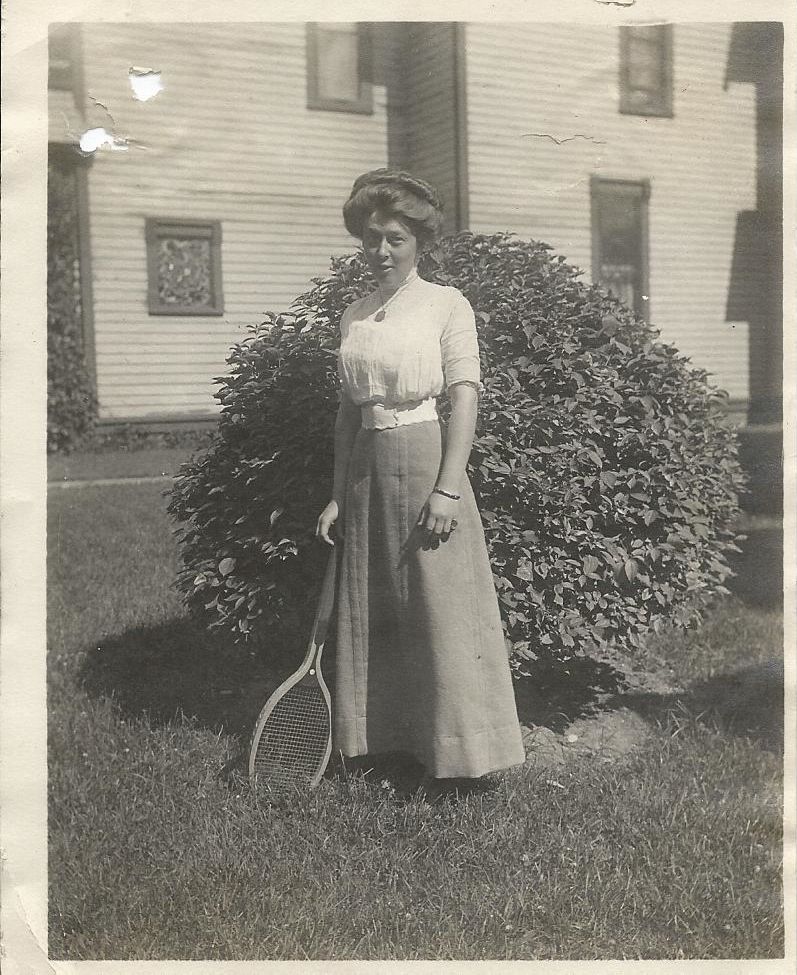 A black and white photo of a woman holding a tennis racquet