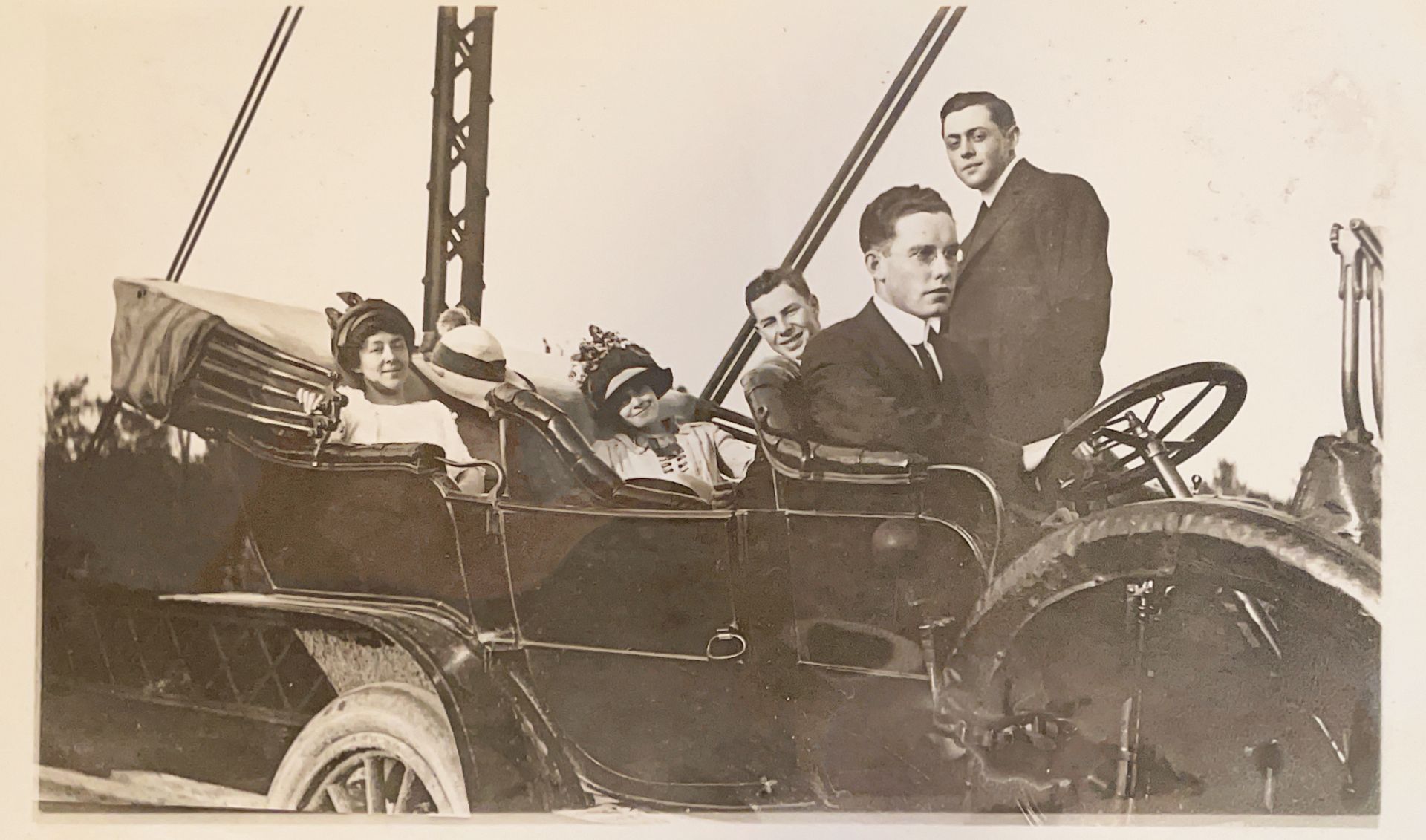 A black and white photo of a group of people in a car