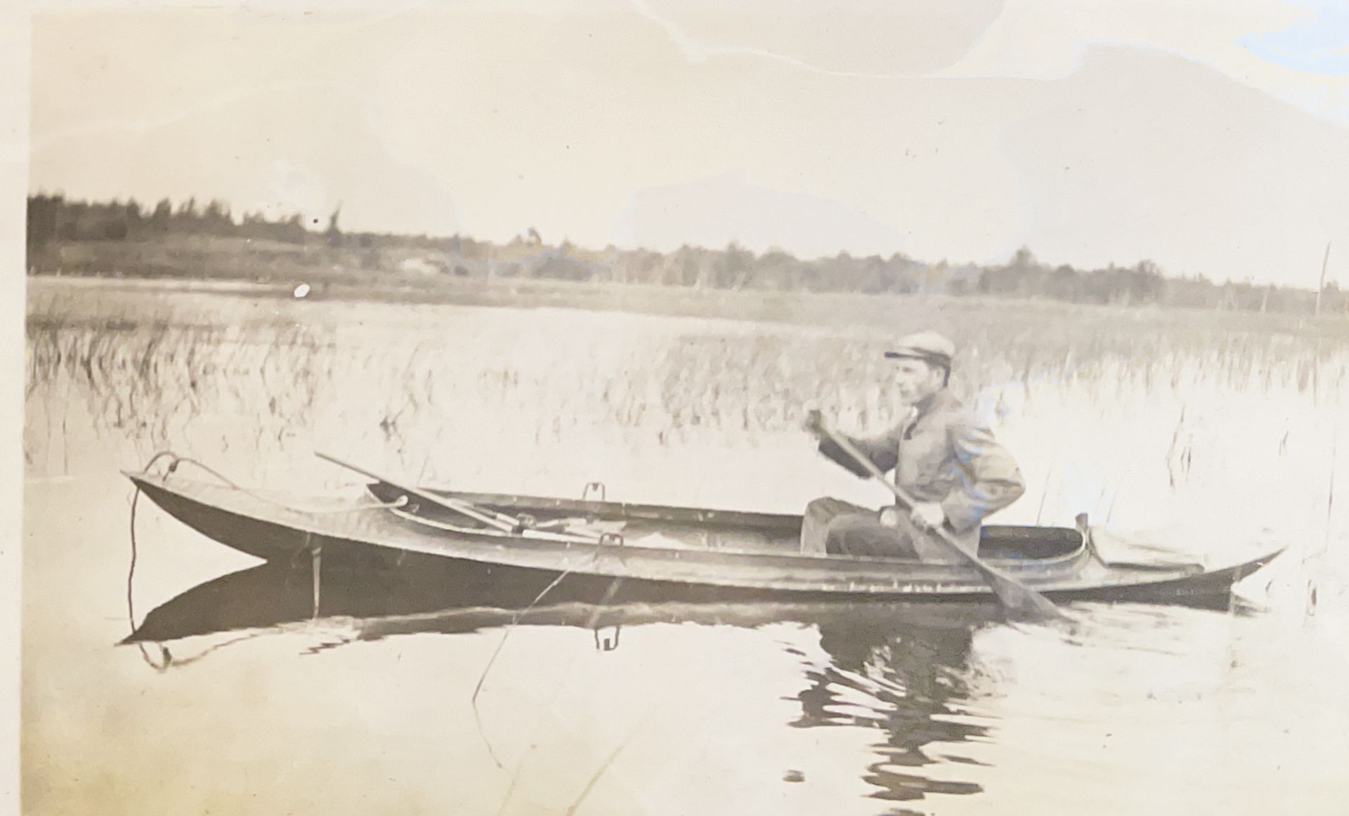 A man is rowing a boat on a lake.