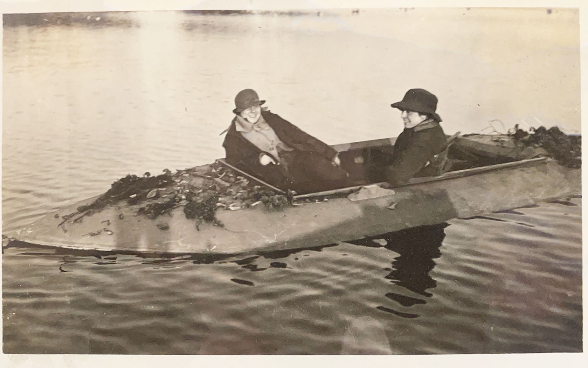 Two people are sitting in a boat in the water.