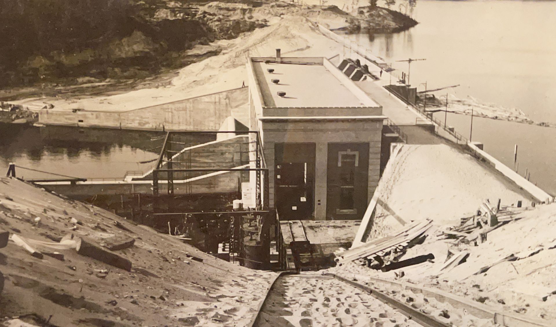 A black and white photo of a building next to a body of water
