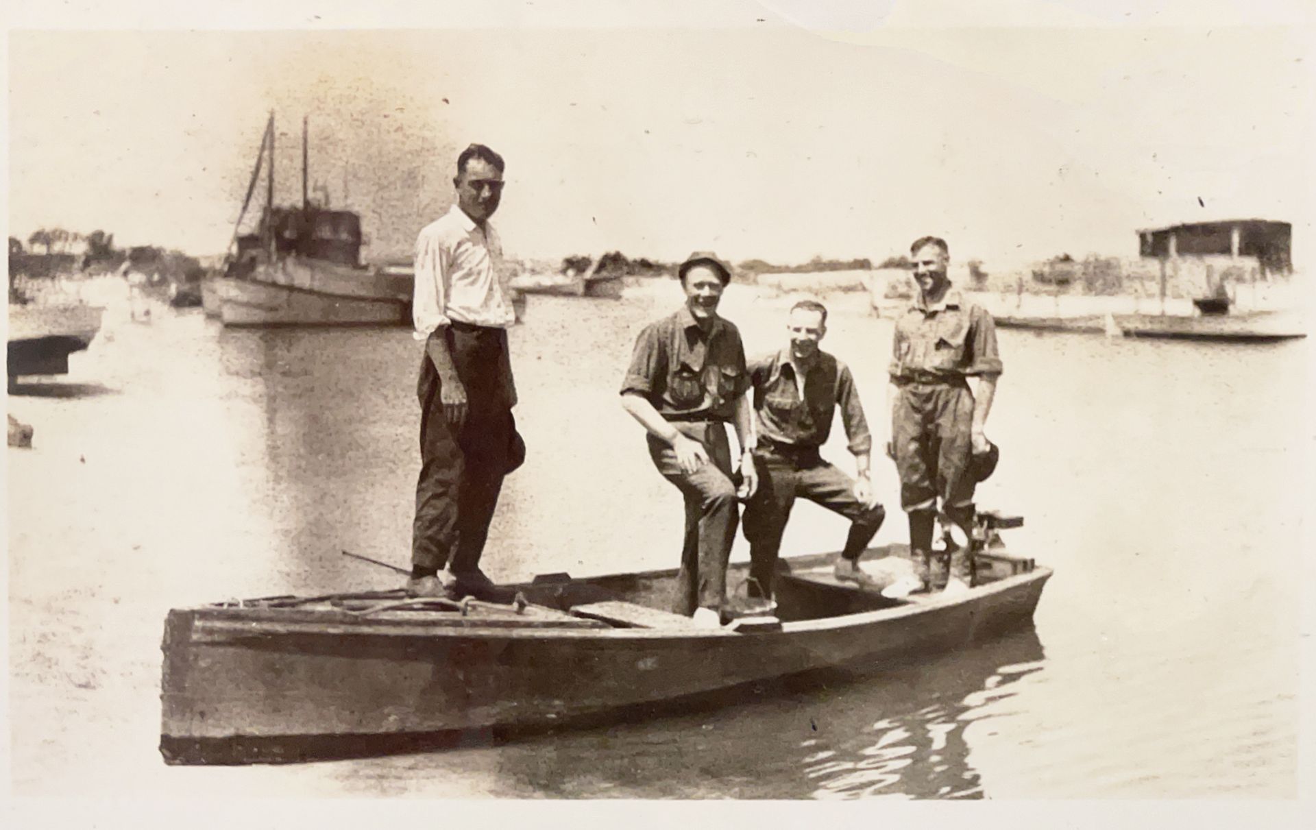 A group of men are standing on a boat in the water