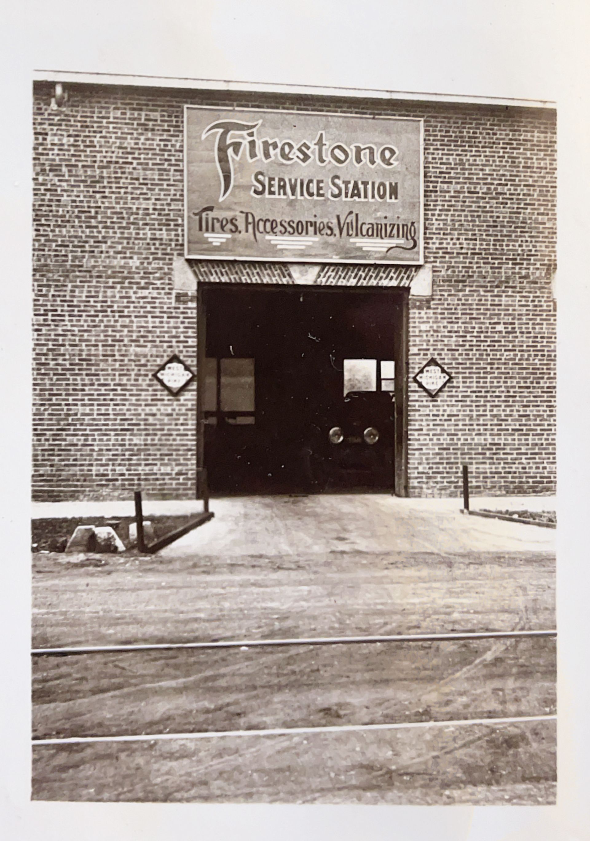 A black and white photo of a firestone service station