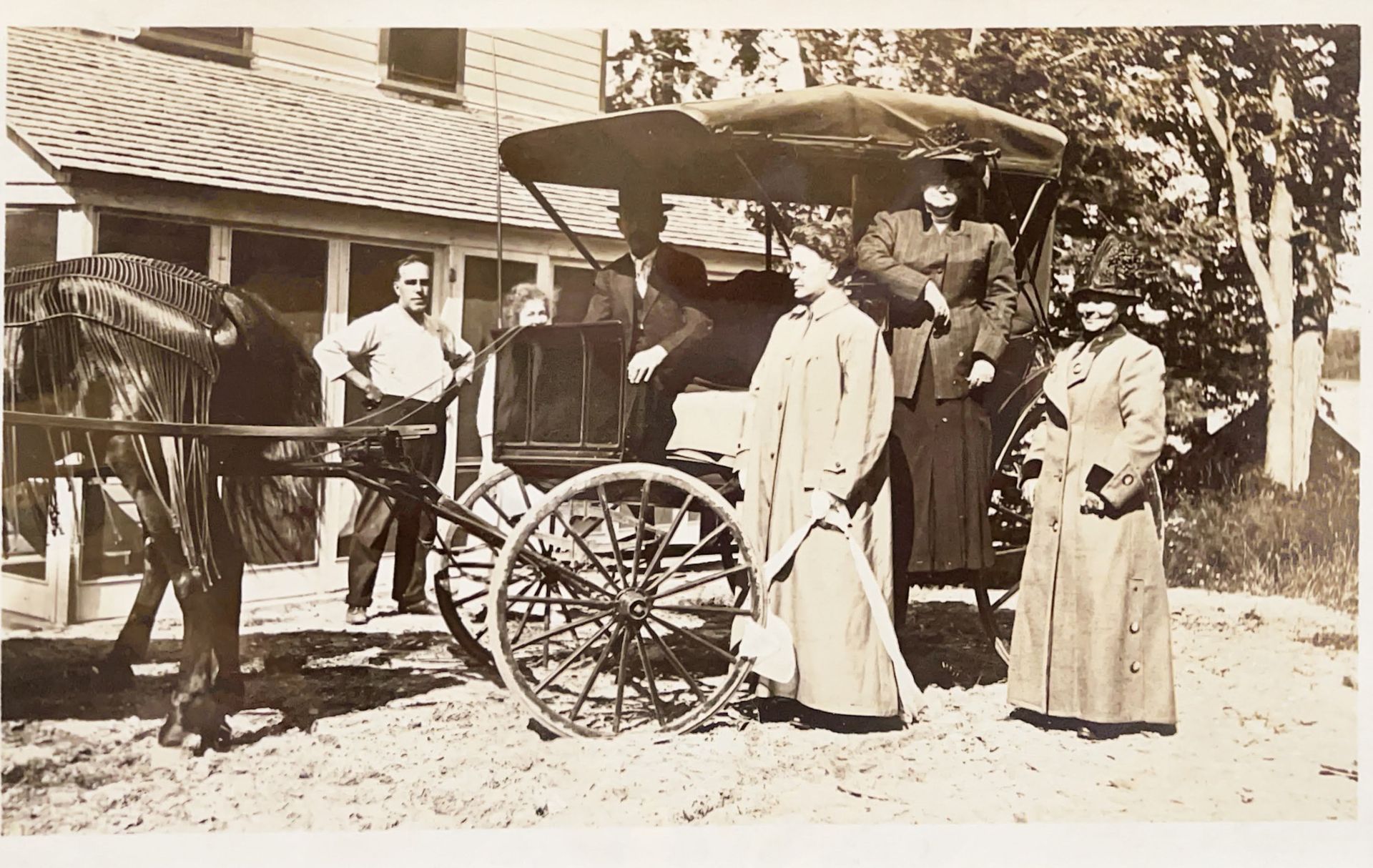 A black and white photo of a horse drawn carriage