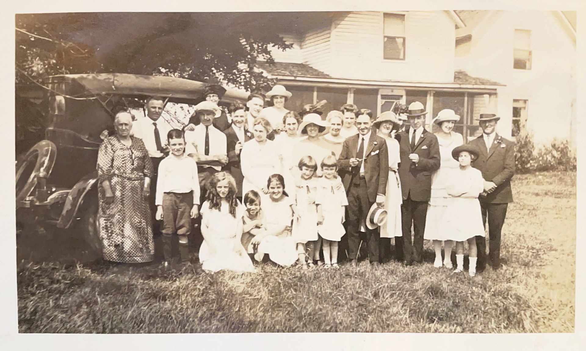 A group of people posing for a picture in front of a house