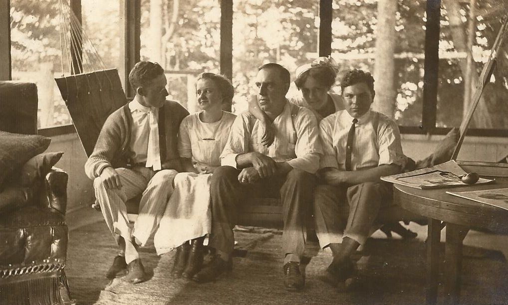 A group of people are sitting on a couch in a living room.