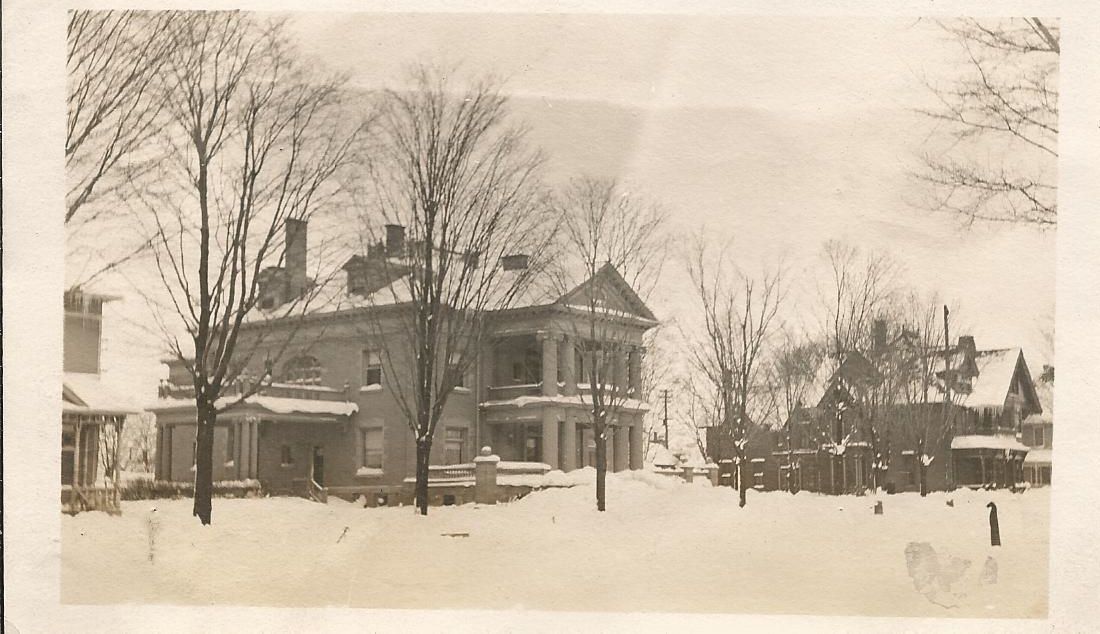 A black and white photo of a house in the snow