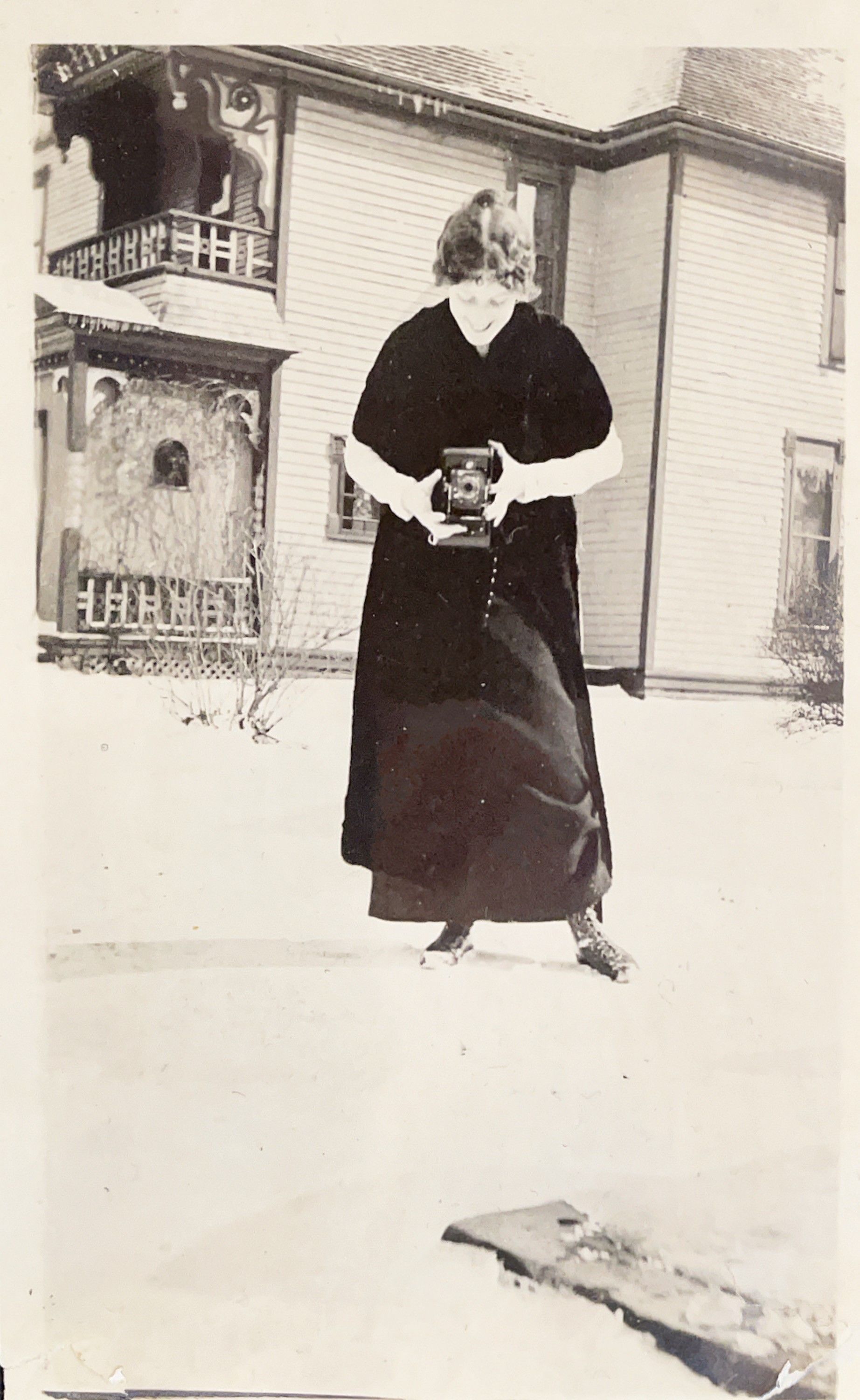 A black and white photo of a woman holding a camera