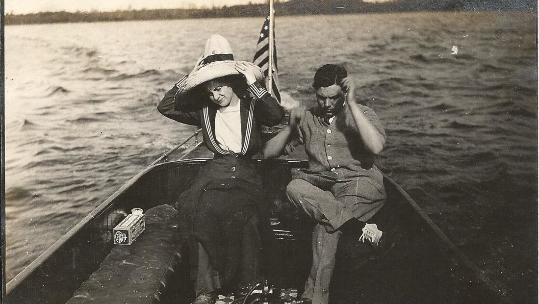 A black and white photo of a man and woman in a boat