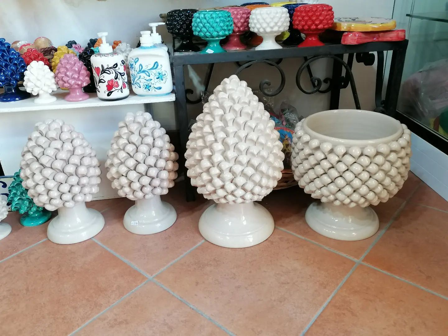 Sono esposte varie sculture e fioriere in ceramica a forma di pigna.