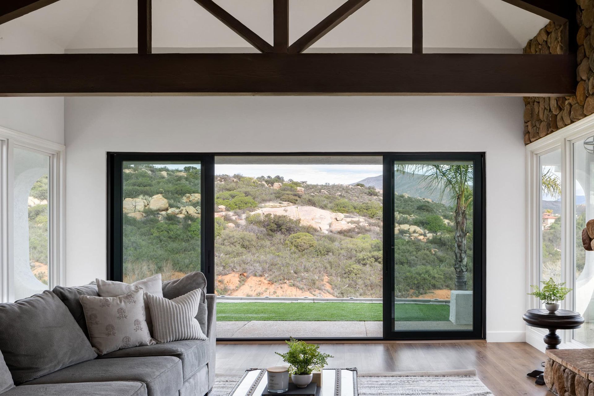 A living room with a couch , coffee table , and sliding glass doors.