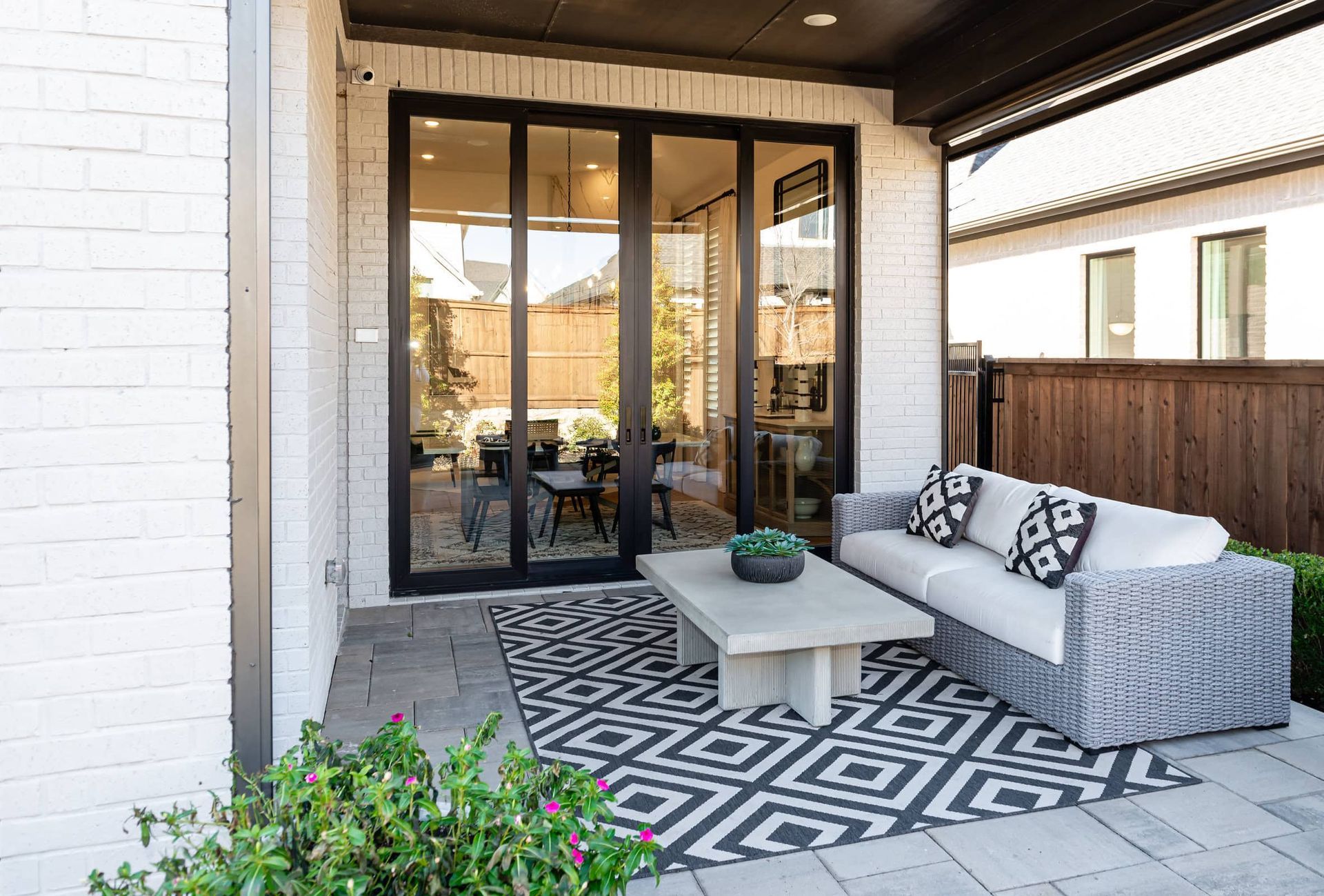 A patio with a couch , coffee table , and rug.