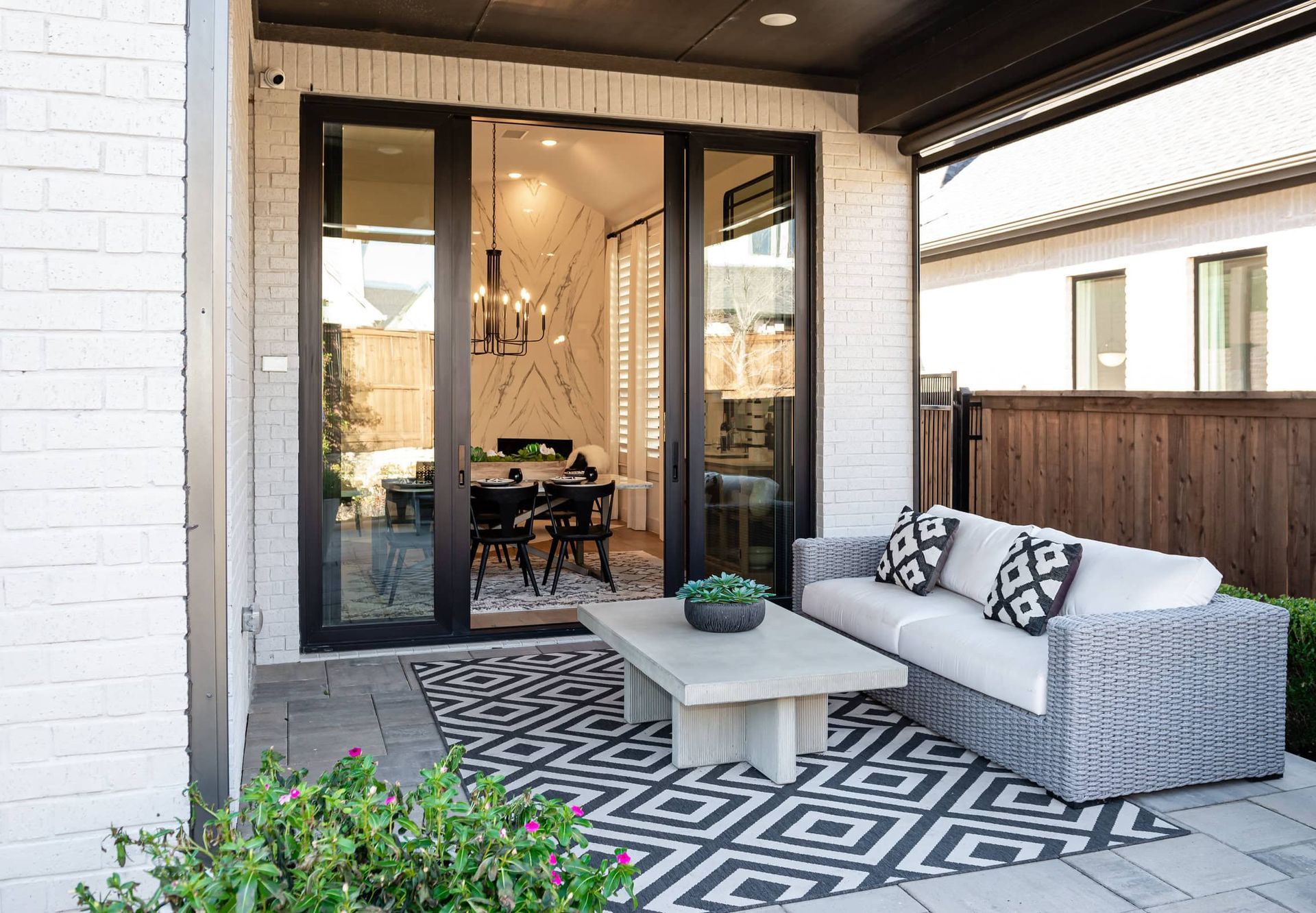 A patio with a couch , coffee table , and rug.