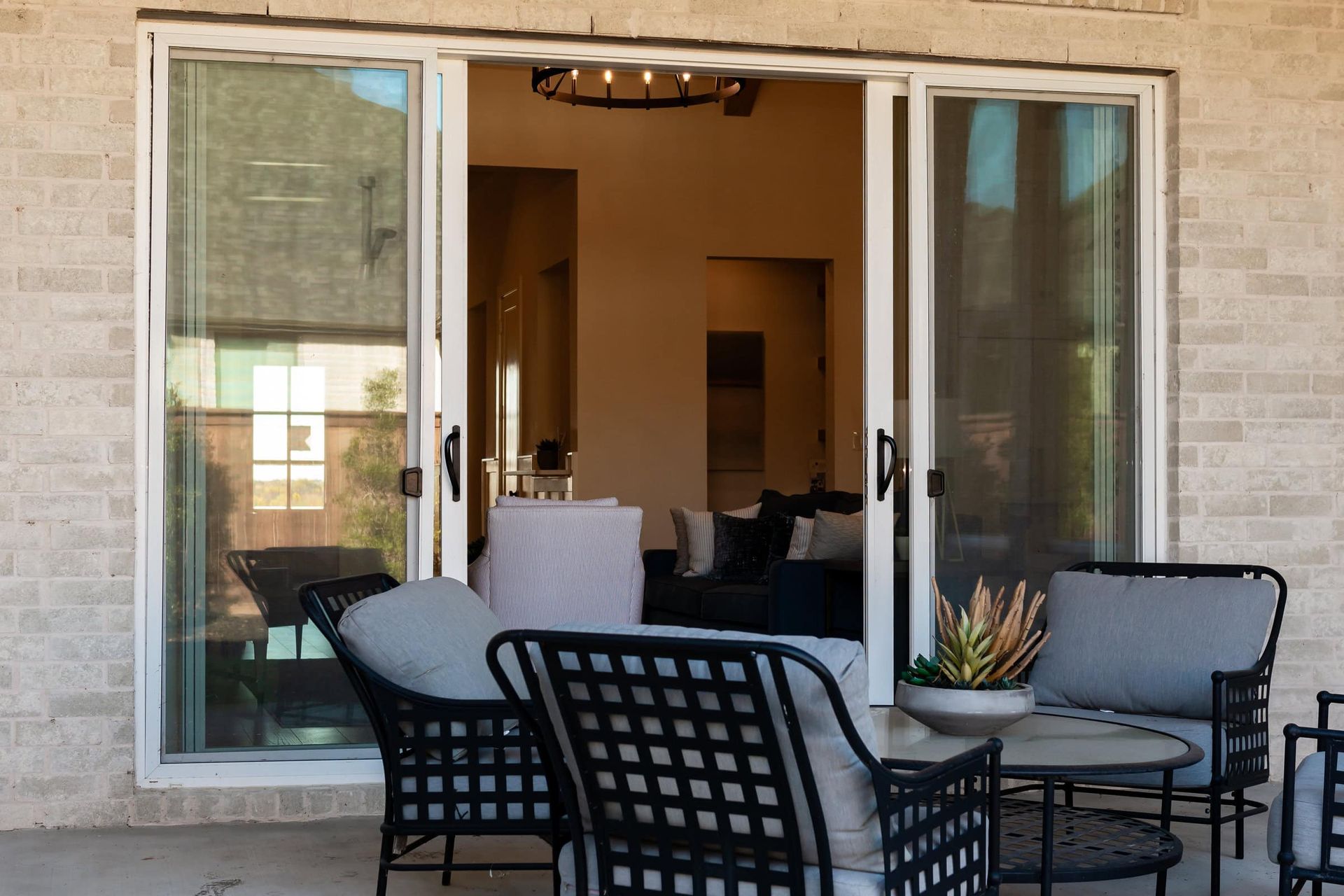 A patio with furniture and a sliding glass door leading to a living room.