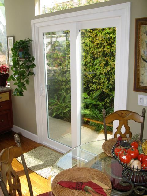 A dining room with a table and chairs and a sliding glass door