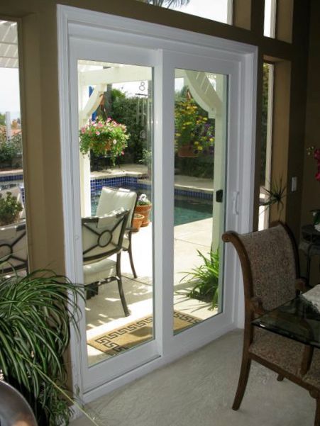 Sliding glass doors open to a patio with chairs and a table