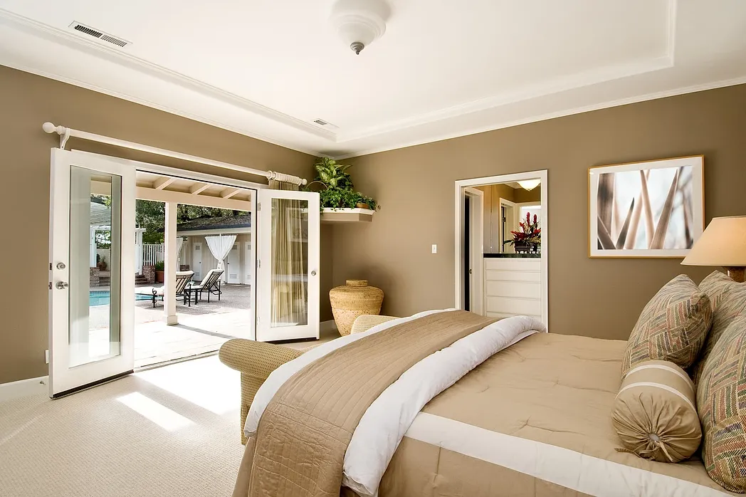 A bedroom with a large bed and sliding glass doors