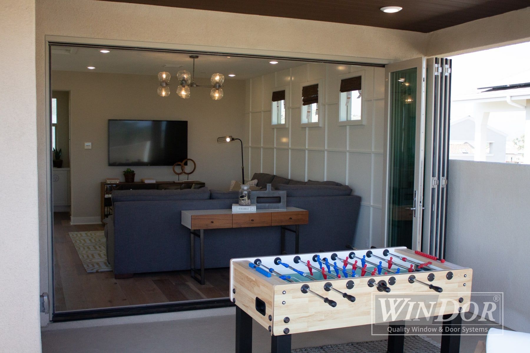 A living room with a foosball table and a flat screen tv.