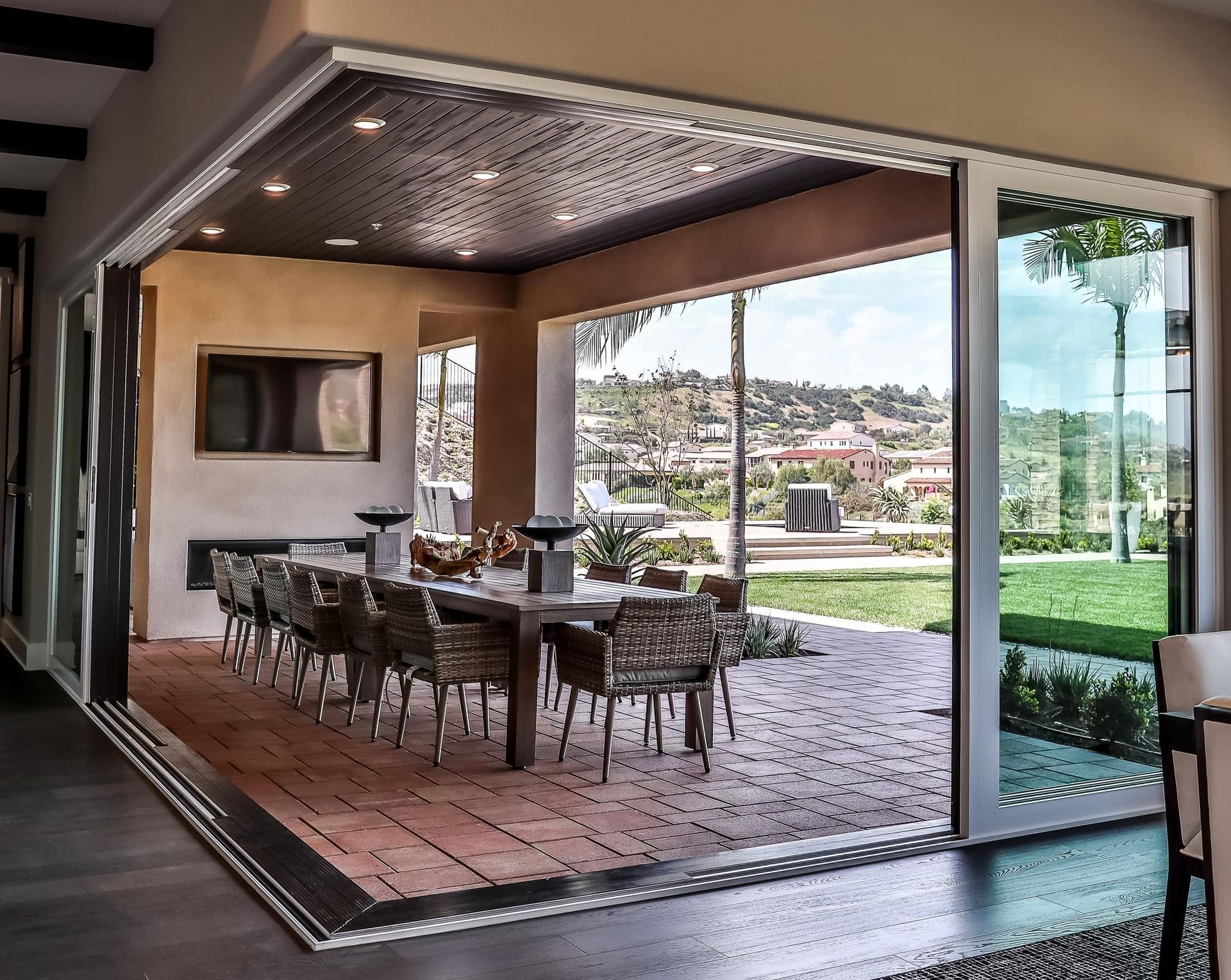 A dining room with a table and chairs and sliding glass doors