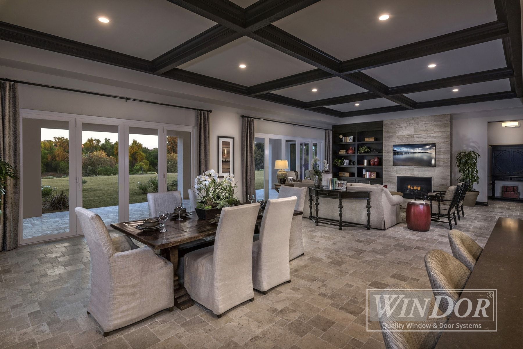 A living room with a dining table and chairs and a fireplace.