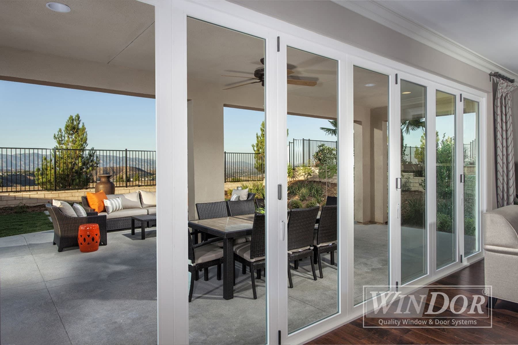 A patio with a table and chairs and a ceiling fan