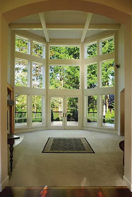 A white house with a large deck and a table and chairs on it
