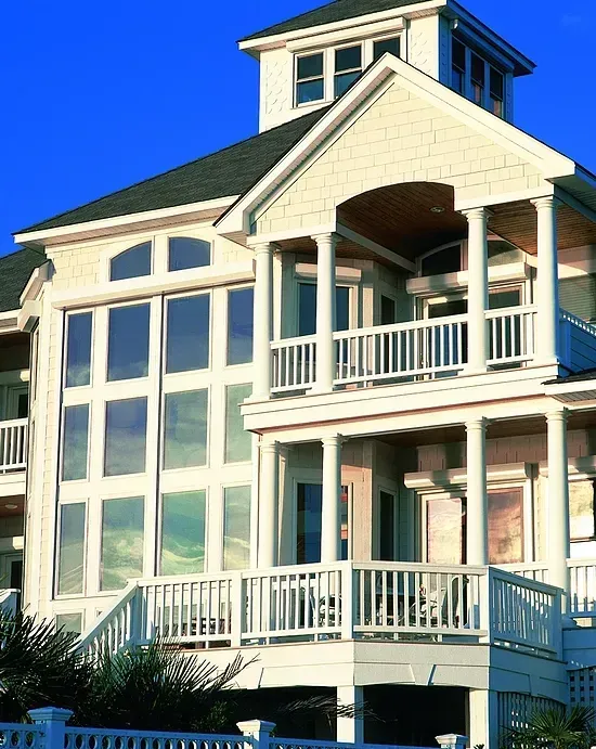 An artist 's impression of a modern house with a black roof and lots of windows.