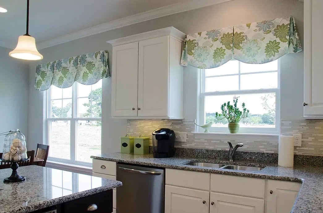 A kitchen with blue walls , white cabinets , stainless steel appliances , and a large island.